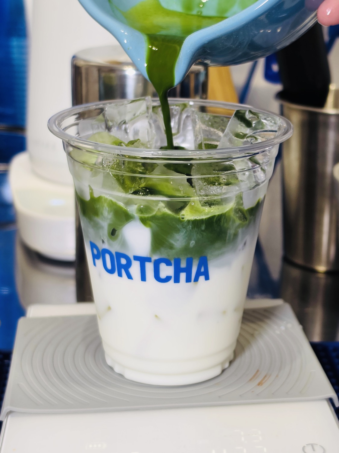 Fresh matcha being poured into a Portcha iced matcha latte