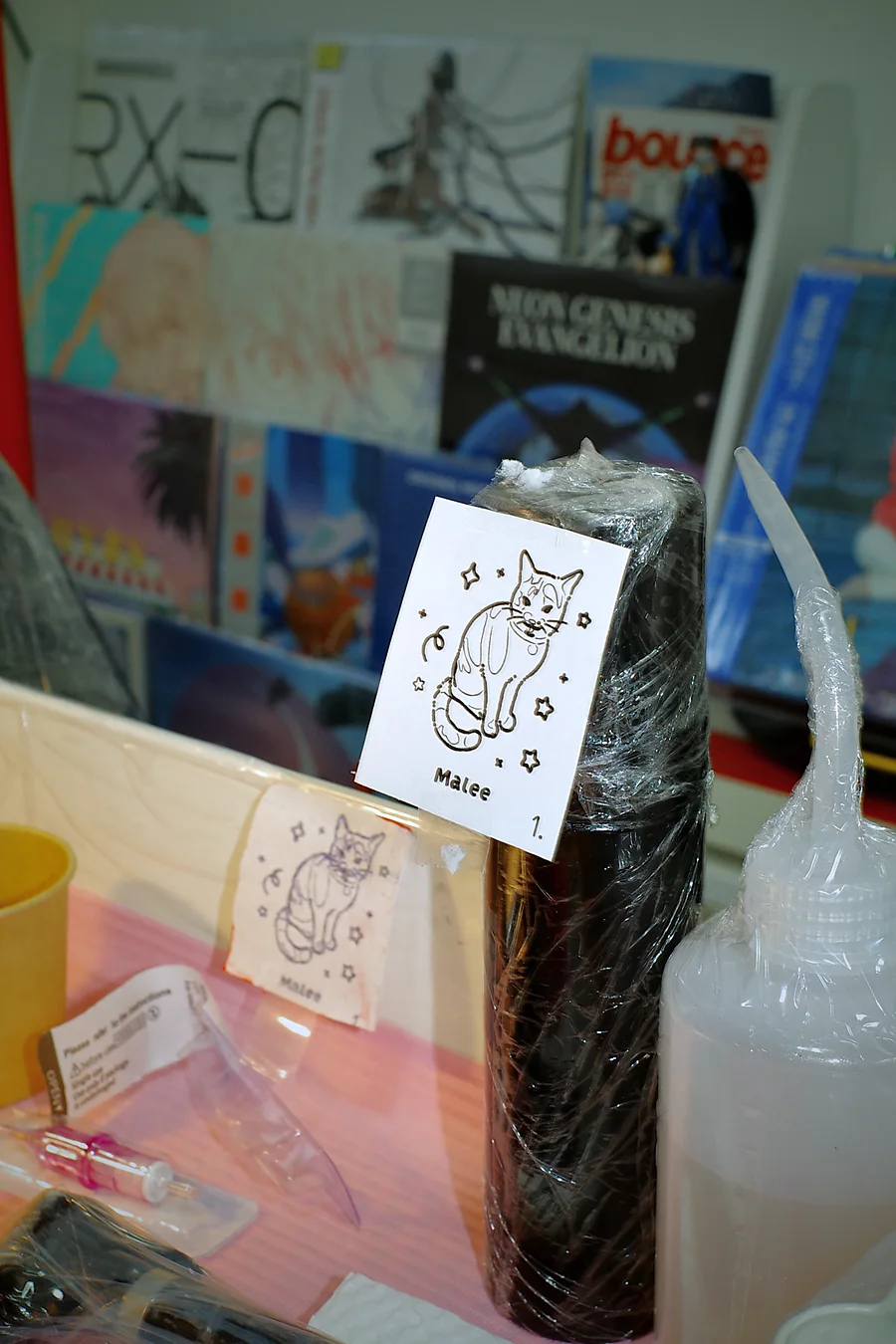 The Malee stencil and design card beside the wrapped tattoo machine before the session