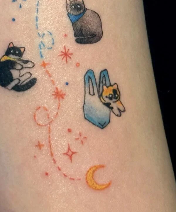 Close up of the tattoo showing the calico sitting inside a plastic bag and the orange moon