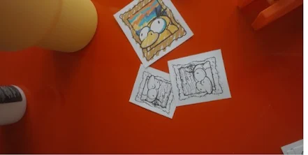 Three sketches on an orange table, two in line and one coloured in