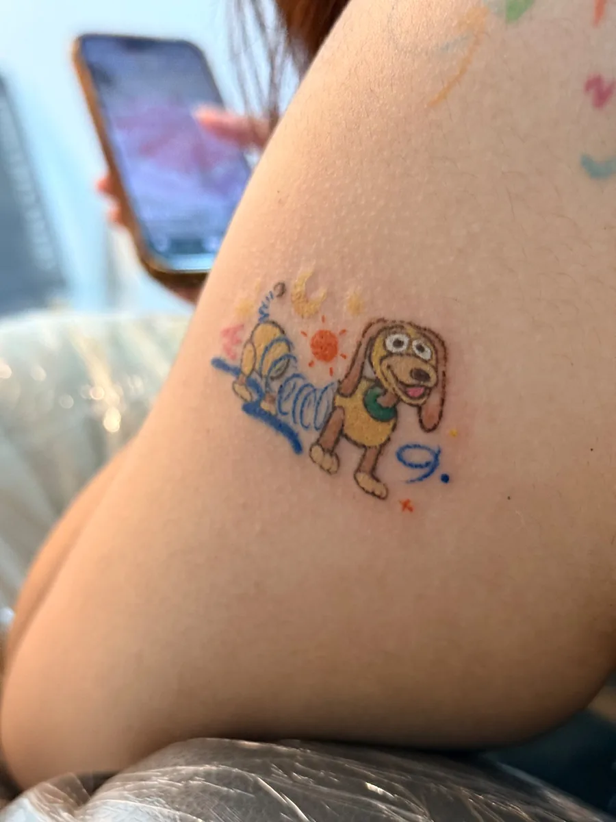 Close up of the crayon style tattoo showing uneven line weight and hand painted colour