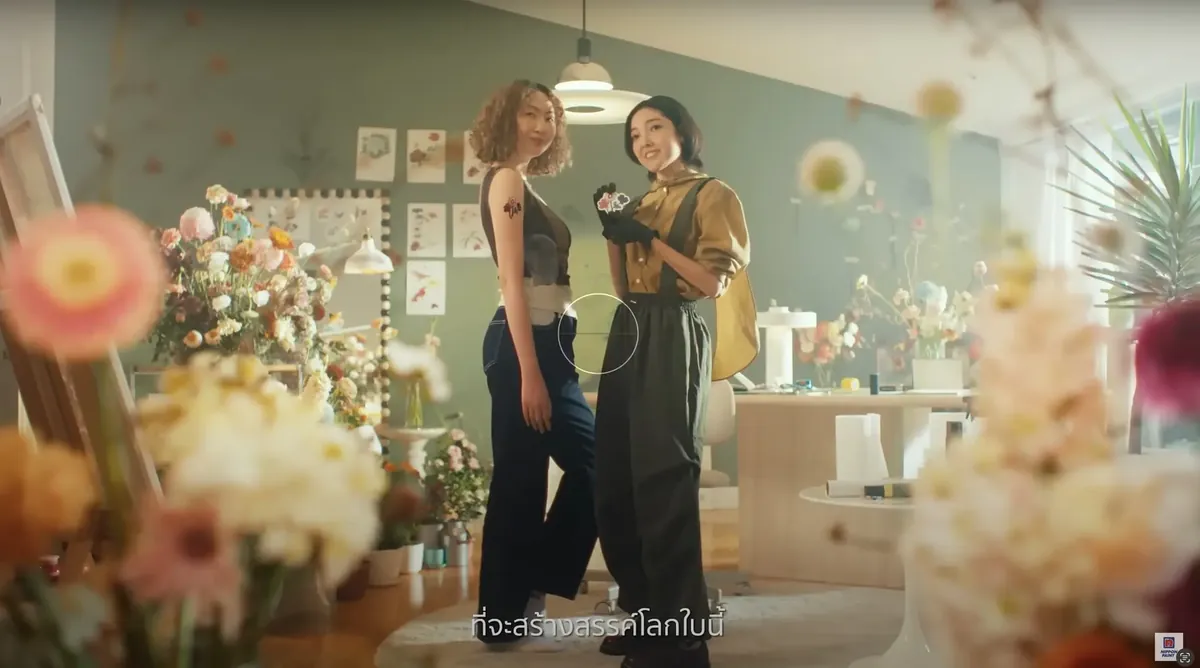Scene from the commercial, a studio surrounded by flowers
