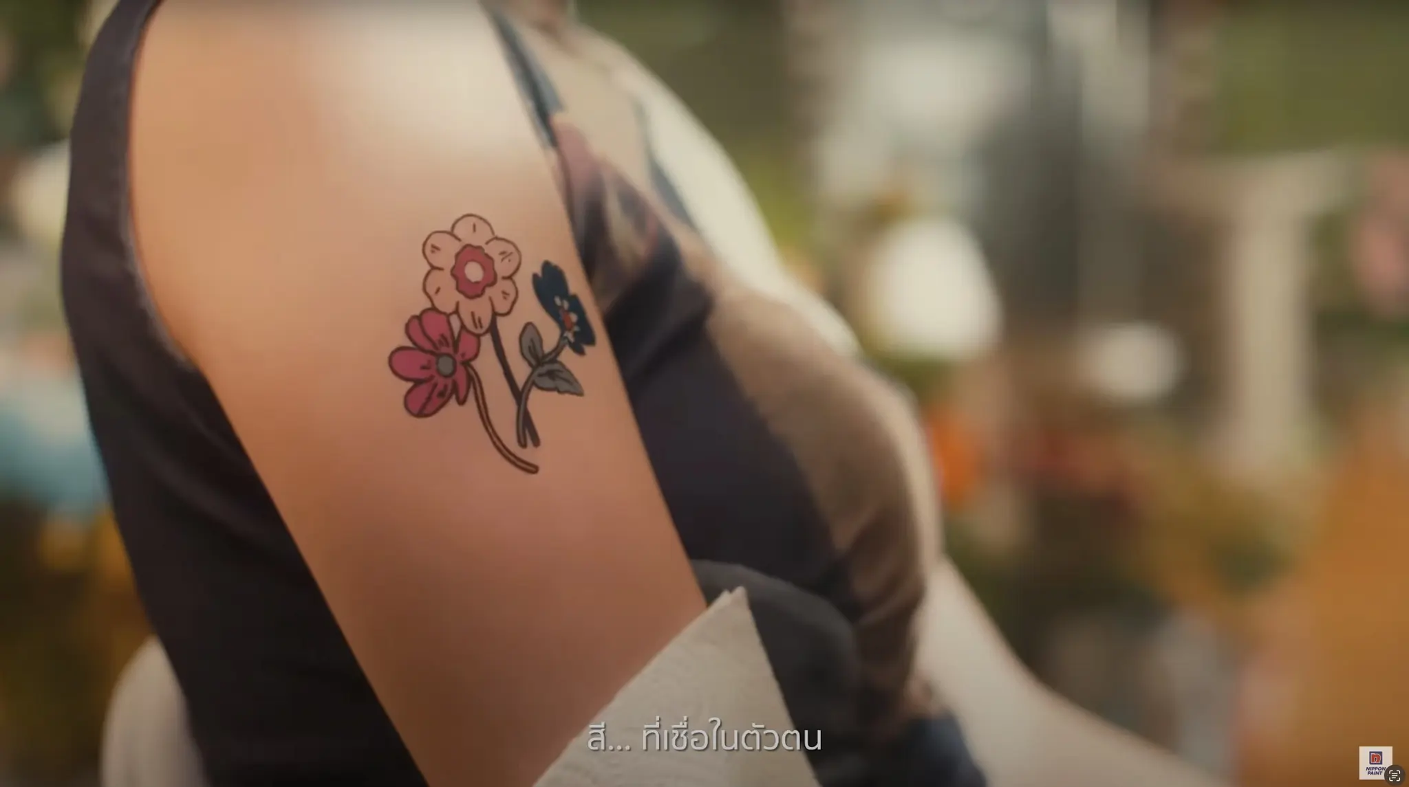 Colourful floral tattoo on an arm by Naive Flora Bangkok