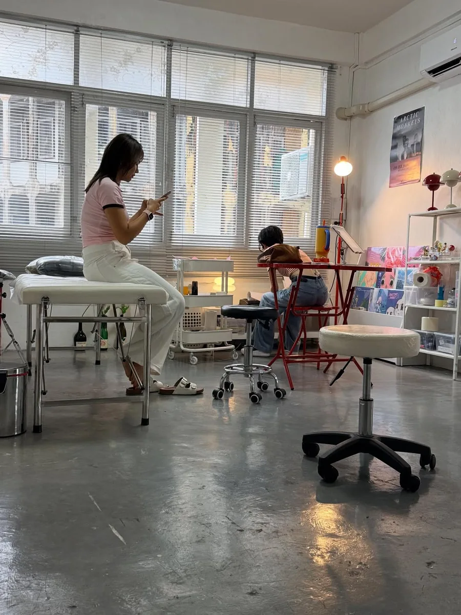 Inside the studio, the client relaxing while the artist prepares the design